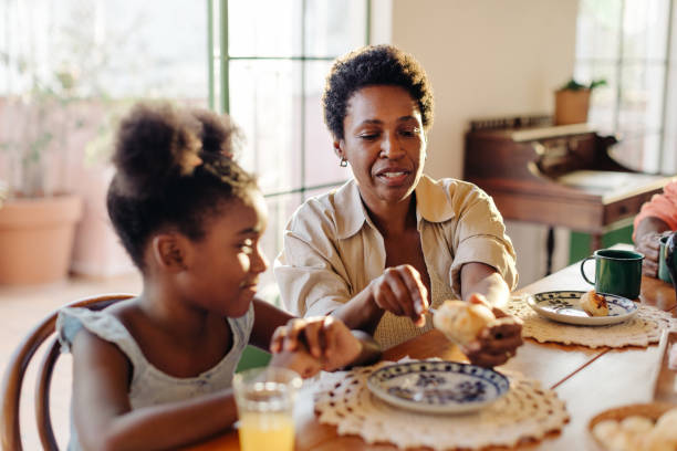 istock Mother serving her daughter with cheese bread rolls on a Brazilian breakfast table 2203558877