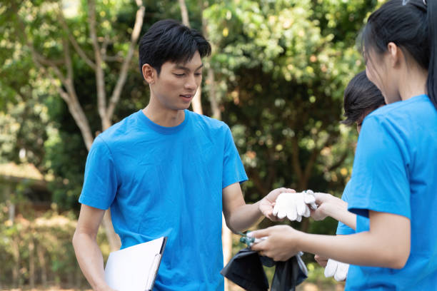 istock Sustainable volunteering. Volunteers exchanging tools and information during an eco-friendly project. 2203559918
