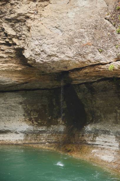 istock The waterfall flows down the cliff and falls into the river. Natural landscape 2203560106