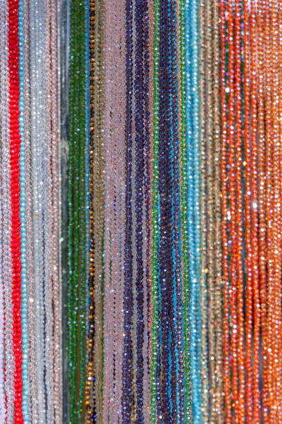 istock Background of multicolored bead strands arranged in vertical rows shimmering surfaces reflect light 2203561442