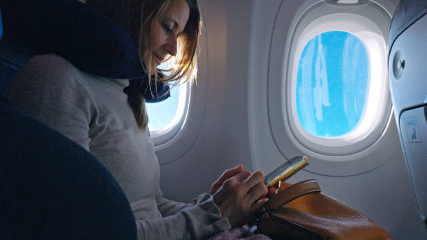 istock Mid Adult Woman Engages with Smartphone During Flight 2203562603
