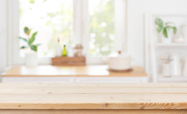 istock Wooden table top on blurred kitchen window interior background for product advertising 2203562613