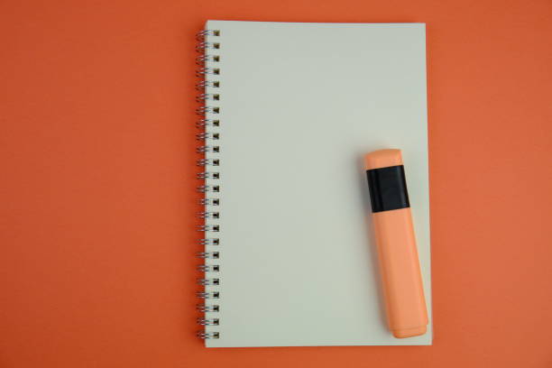 flat lay of a blank note book for text space. Educational and financial concept with text space on white background. surrounded by tools such as pen, alarm clock and calculator