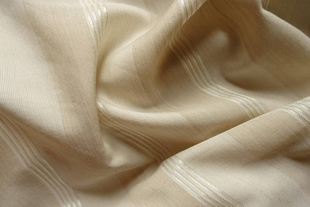istock Soft folds on light beige striped cotton and polyester fabric 2203566041