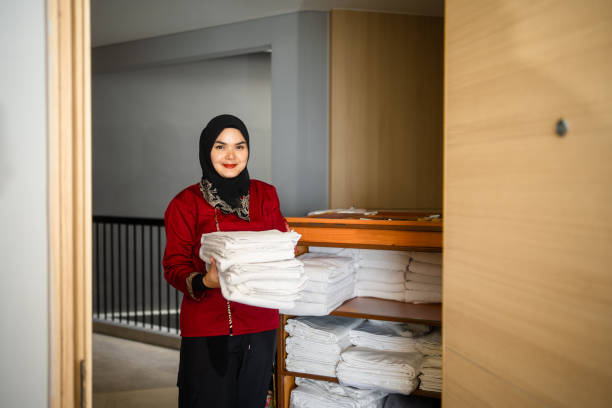 Chambermaid standing in the doorway of an ensuite bathroom in a luxury hotel room