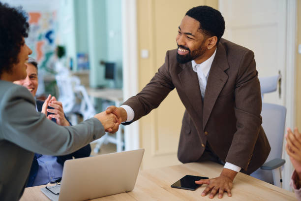 istock Businesspeople shaking hands during a meeting in a modern office 2203570092
