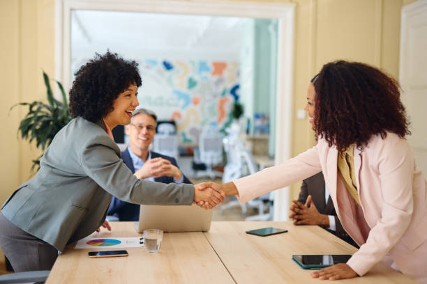 istock Two businesswomen shaking hands during a meeting in a modern office 2203570099
