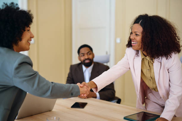 istock Two businesswomen shaking hands during a meeting in a modern office 2203570105