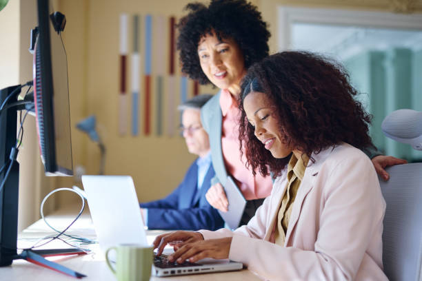 istock Businesswomen working together in modern office using laptop 2203570341