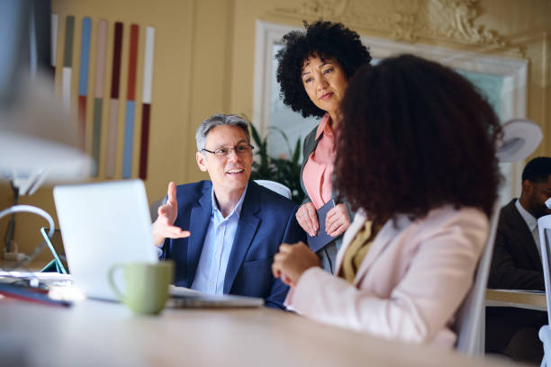 istock Business team discussing a project in a modern office using a laptop 2203570386