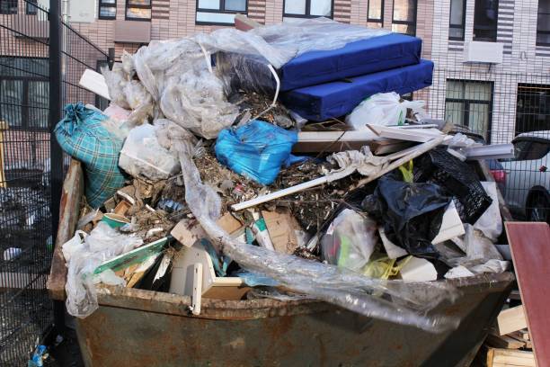 istock Overfilled garbage container with mixed waste. Discarded household items in overflowing dumpster. Urban waste disposal. Outdoor metal dumpster filled with debris. Piled up trash in a commercial skip 2203570467