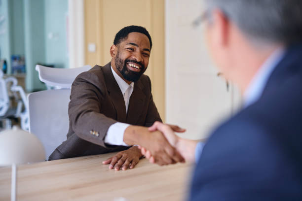 istock Two businessmen shaking hands during a meeting in a modern office 2203570518