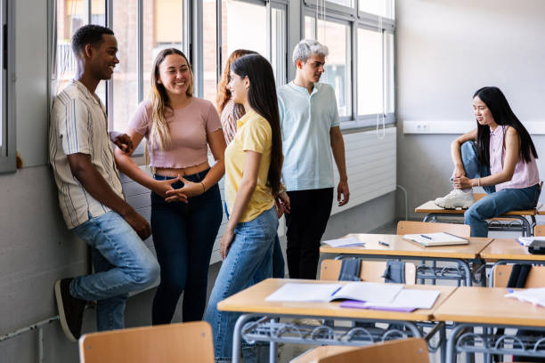 istock Diverse young high school students hanging out in classroom during break 2203571988