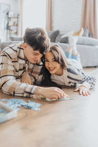 istock Young couple having fun with puzzles at home 2203581158