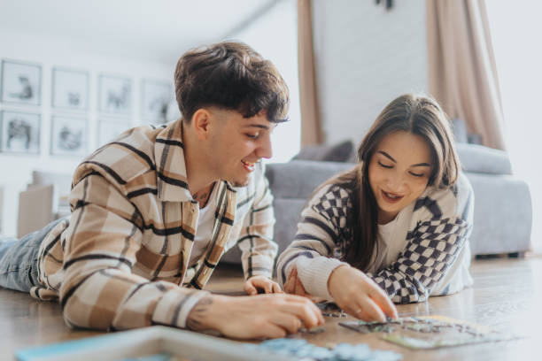 istock Young couple having fun with puzzles at home 2203581365