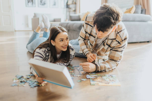 istock Young couple having fun with puzzles at home 2203581882