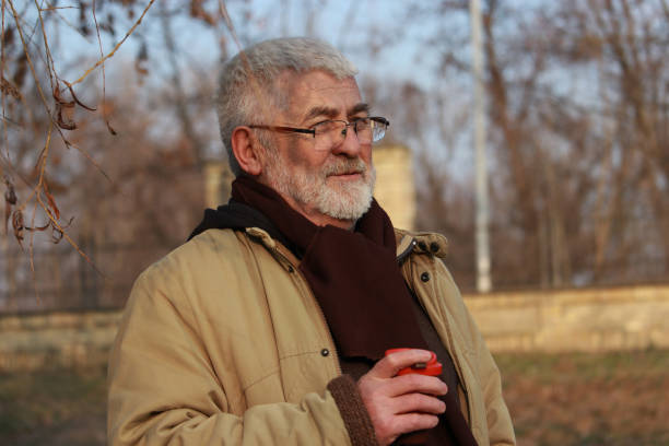 istock Senior man walking in public park 2203582480