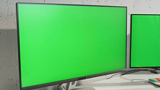 istock Two green screen monitors at light office table zoom out. Woman working mockup 2203584197