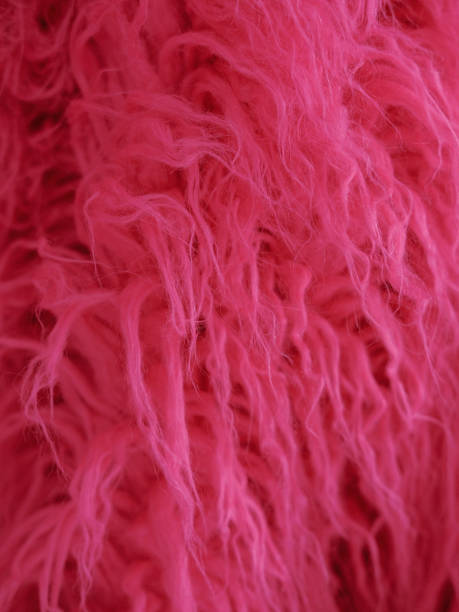 istock faux fur with long pile pink color, textured background 2203585011