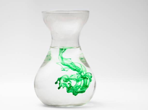 Green dye dissolves in a jug of water