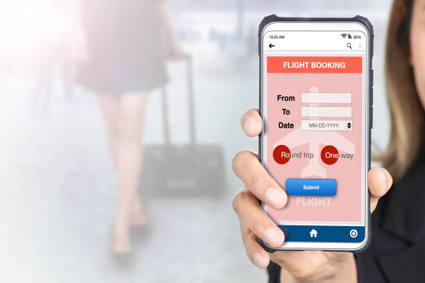 istock Businesswoman holding smartphone showing flight e-booking application on screen. 2203586471