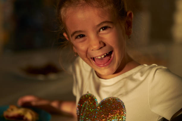 Young girl eating in kitchen.