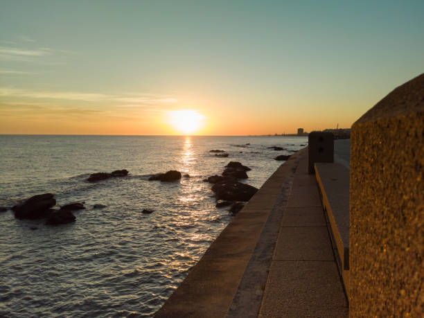 Sunset in the city with orange reflections in the sea.