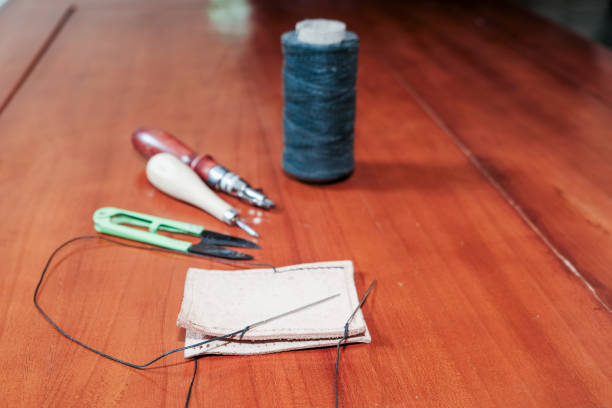 Leather crafting tools for hand stitching on wooden table, Leather and the craft tools.
