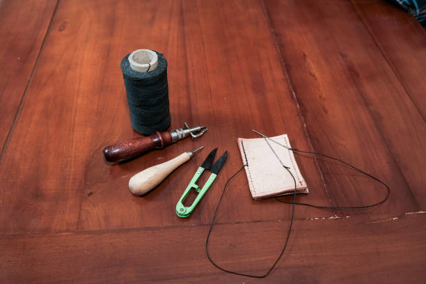 Leather crafting tools for hand stitching on wooden table, Leather and the craft tools.