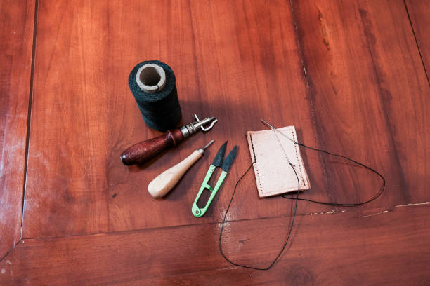 Leather crafting tools for hand stitching on wooden table, Leather and the craft tools.