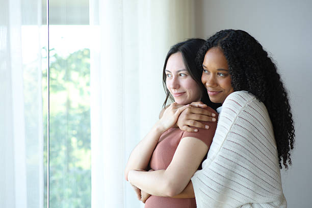 istock Satisfied lesbian interracial couple at home contemplating 2203592189