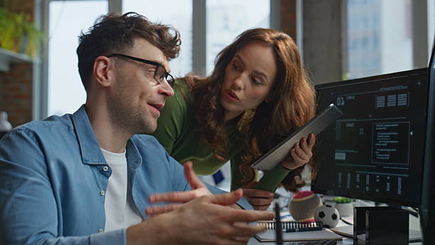 istock Positive office couple discussing task working together at computer closeup 2203593965