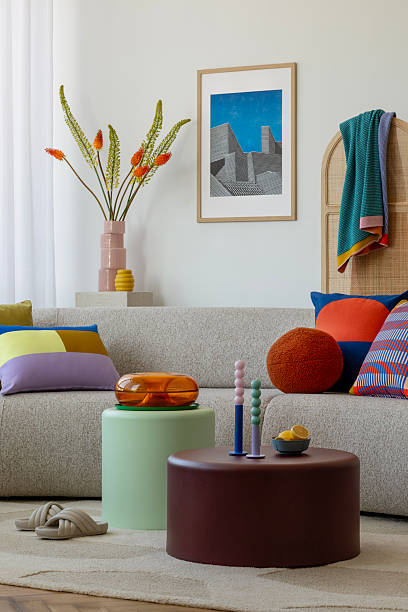 istock A cozy living room with a beige sofa adorned with colorful pillows and throws, complemented by modern art and vibrant decor accents 2203596286