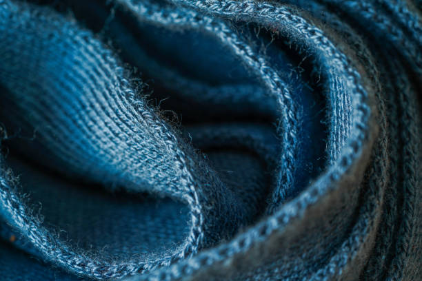 Detailed close-up of soft blue knitted fabric, showcasing a cozy texture and intricate stitching, perfect for fashion and clothing designs.