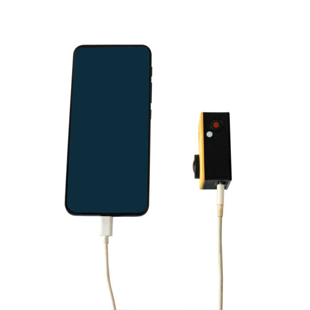 istock Plugging a charger in a smartphone and action camera. 2203604392