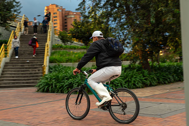 Man riding a bicycle on a sidewalk with a bridge staircase in the Colombian capital. Bogota, Colombia. January 1, 2017.
