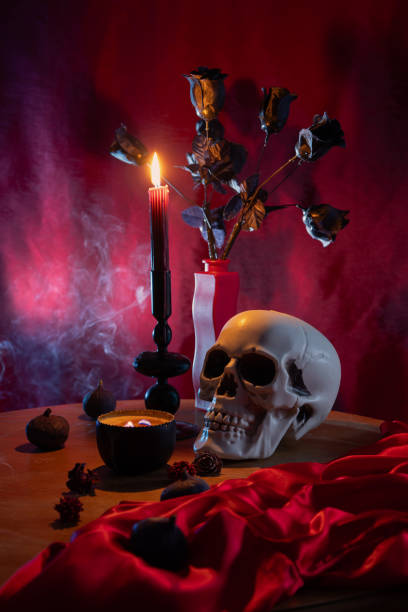 istock scull and burning candles on dark red background 2203608830
