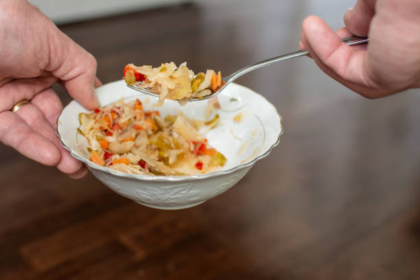 istock Close-up view of a man's hands picking up a  fermented salad 2203610220