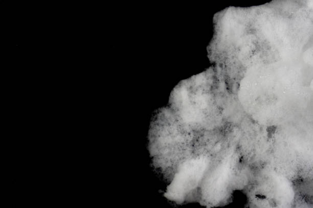istock Close-up studio shot of a cloud of white foam over a black backdrop, highlighting its texture. 2203616225