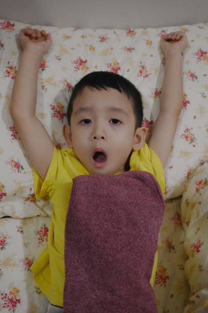 Cute Asian Little Boy Wake up on bed . With a sleepy face.