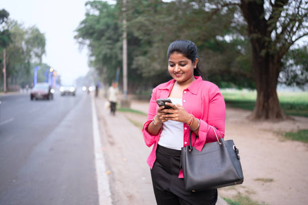 istock Happy Young Woman Using Smartphone Outdoors 2203617830