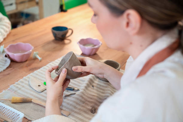istock Woman working on her coffee mug in ceramic studio 2203618030
