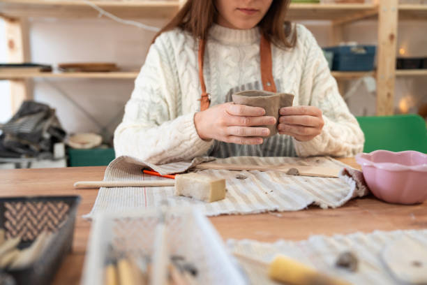 istock Woman using clay to make handmade mug at pottery studio 2203618496