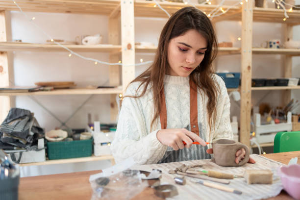istock Woman working on her coffee mug in ceramic studio 2203618733