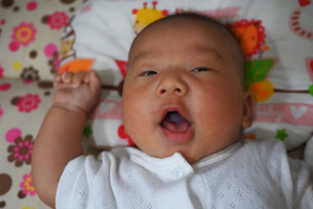 Cute little newborn baby boy looking at camera