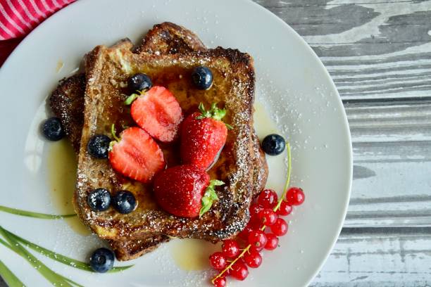 istock French toast crowned with vibrant strawberries, Red currant, blackberries 2203623311