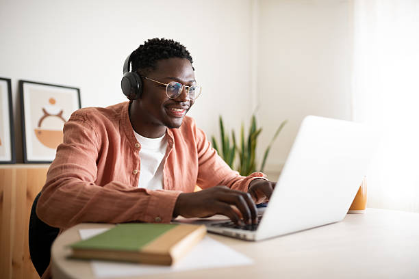 istock Young man working from home enjoying his job using laptop and headphones 2203623402