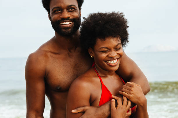 istock Happy couple embracing at the beach in summer sunlight 2203625930