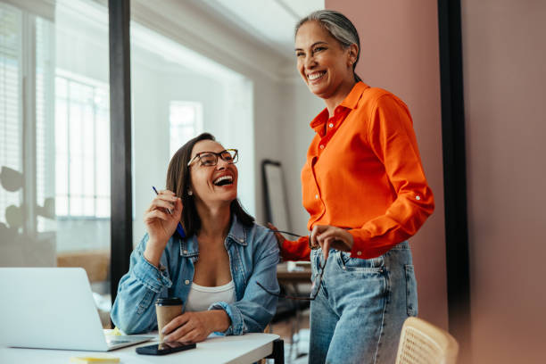 istock Happy employees laughing and collaborating in a modern office 2203626062