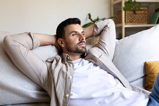 istock Serene man relaxing on sofa: finding peace and tranquility at home 2203626307